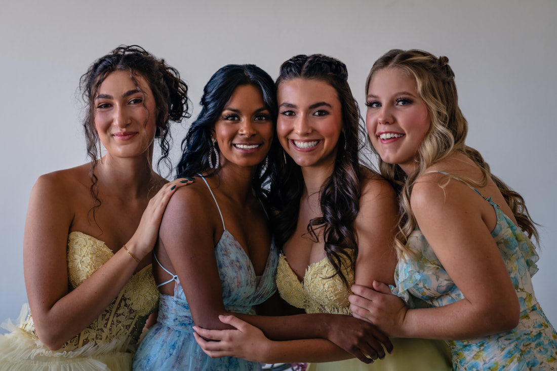 Four girls wearing yellow and blue floral dresses studio space Parker Colorado Senior Pictures