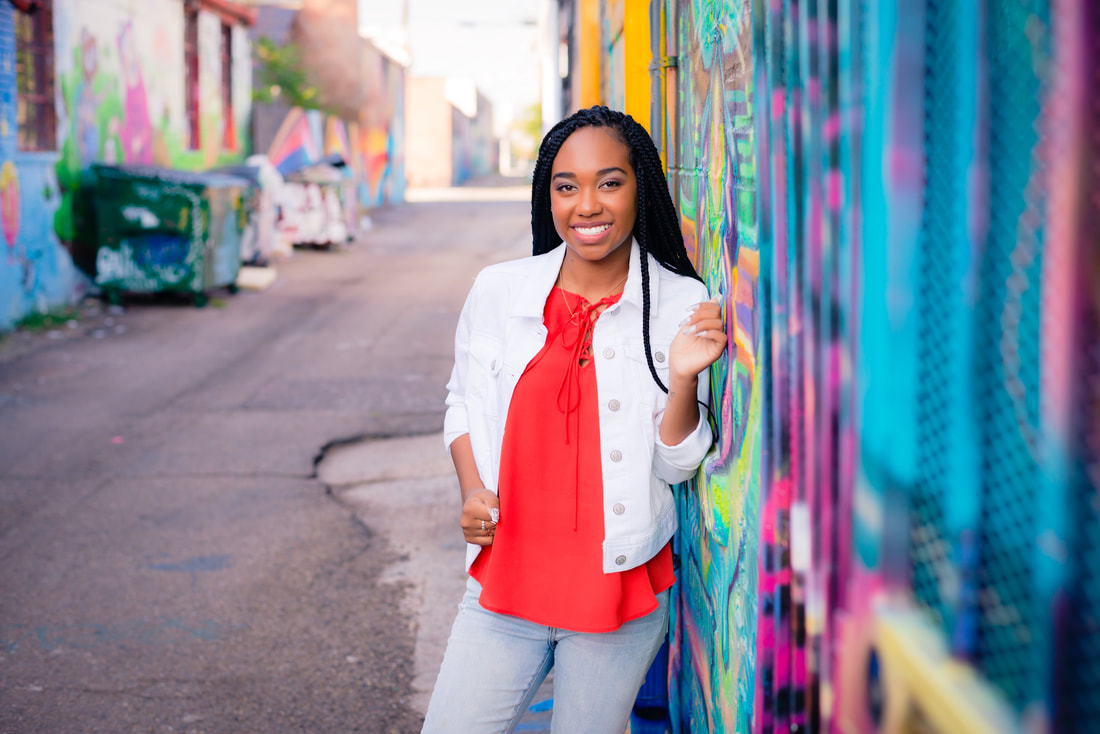 girl leaning on colorful wall in downtown denver colorado rino district for senior pictures