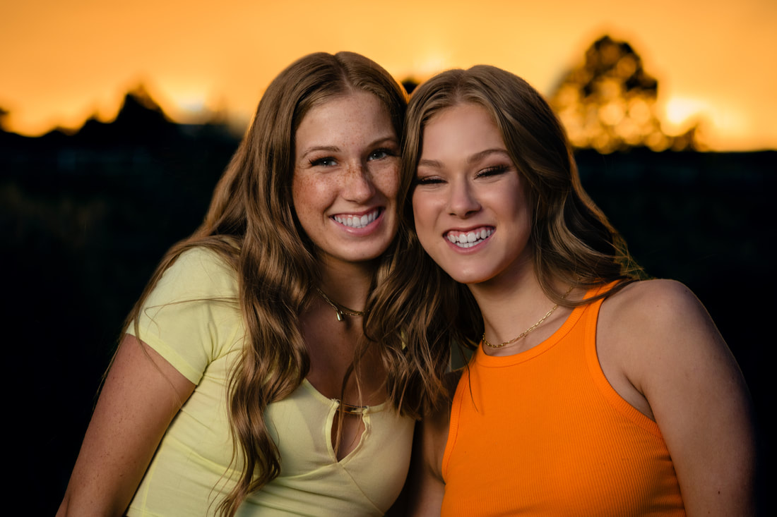 Sisters wearing orange and yellow at golden hour for senior pictures Parker Colorado