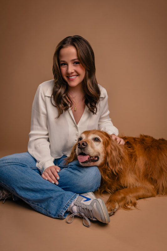 Girl wearing a white blouse with blue jeans and sneakers with her dog parker colorado for senior pictures