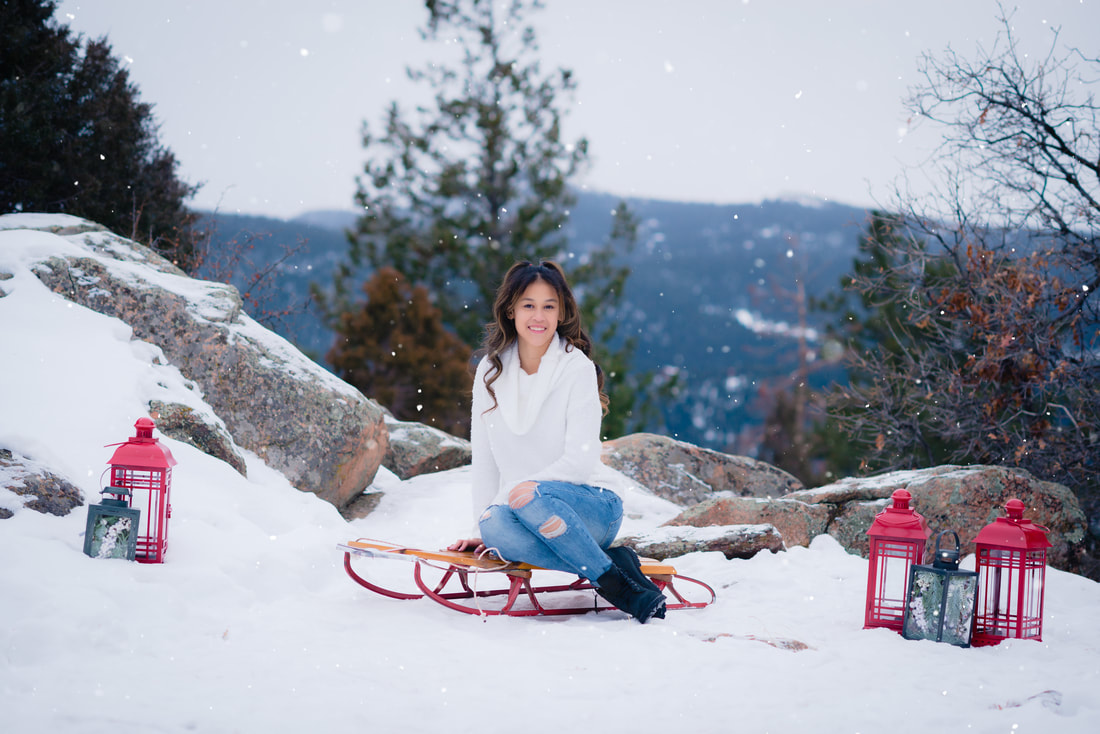 Winter Wonderland Senior Picture Ideas with mountains, snow, red lanterns, and antique sled.