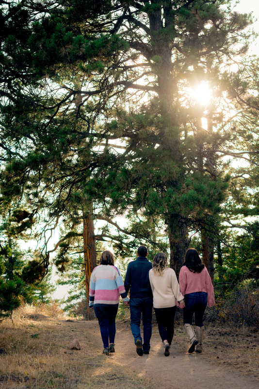 Family walking along path with pine trees around for family portraits