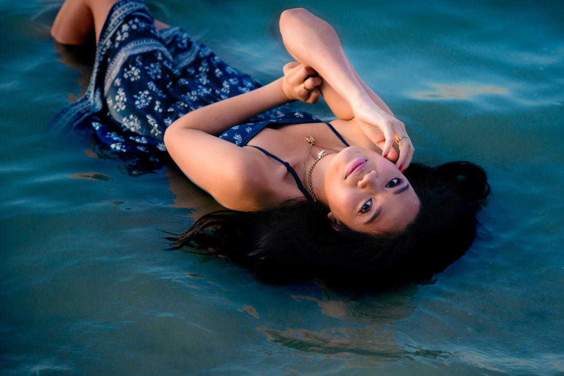 Girl laying in water looking back at the camera for senior pictures 