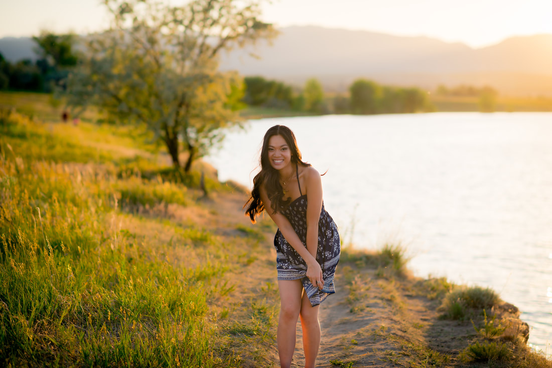 Girl laughing at the camera on path during sunset for senior pictures  