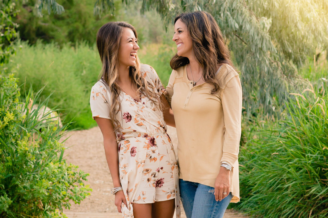 Mom and daughter laughing at each other for senior pictures