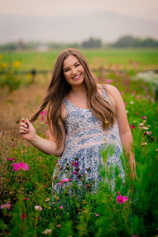 Girl in floral shirt in flower field for senior pictures