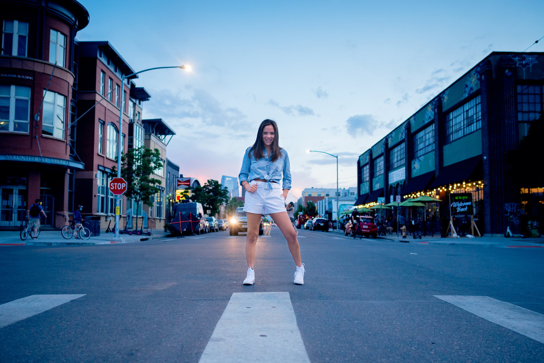 Brunette girl standing in street in Denver's Rino District for senior pictures 