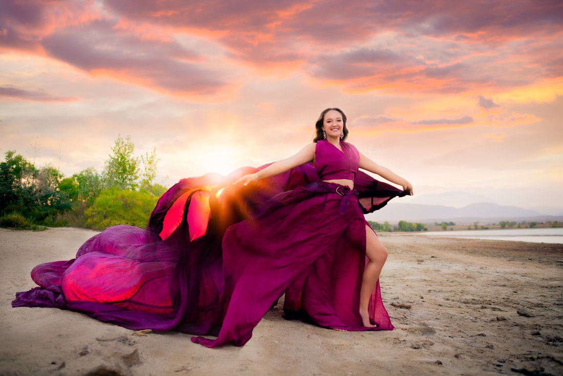 girl in purple flowy dress on beach at sunset for senior pictures